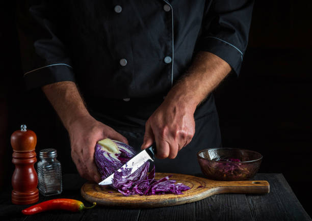 istock A professional chef cuts red cabbage with a knife. Cooking vegetable salad in the restaurant kitchen. Vegetable diet idea. 1464705925