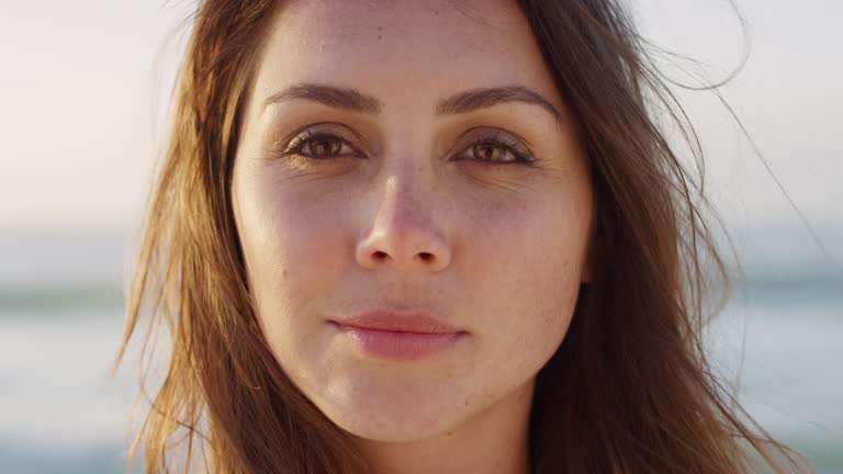 Face, freedom and woman peace, relax by the beach in summer in hawaii. Zoom portrait of the facial of a young, calm and beautiful female laughing and looking relaxed at the sea and seaside on holiday