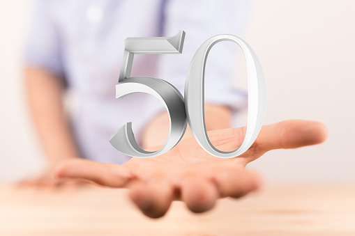 A person presenting a 3D render of 50 years anniversary celebration logotype