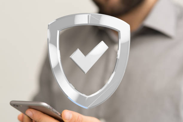 istock Silver 3d rendered shield sign hovering over a smartphone in a man's hand 1464707290