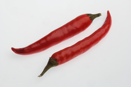 A shot of the red ripe chili hot peppers isolated on white background.