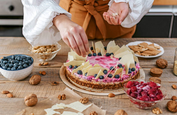istock Female decorating a homemade cheesecake with berries 1464708891