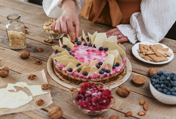 istock Female decorating a homemade cheesecake with berries 1464708901