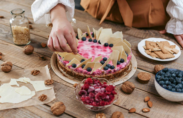 istock Female decorating a homemade cheesecake with berries 1464708903