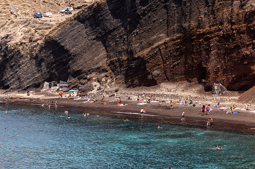 Santorini, Greece - July 01, 2021: The famous Red beach on the south coast of Santorini island, Cyclades, Aegean Sea.