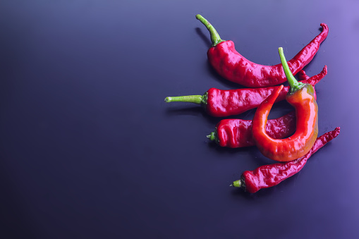 A heap of hot red chili peppers isolated on the dark background
