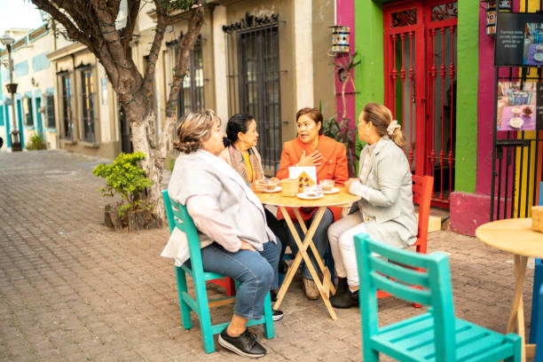 amigos mayores hablando en una mesa en una cafetería al aire libre - coffee buzz fotografías e imágenes de stock