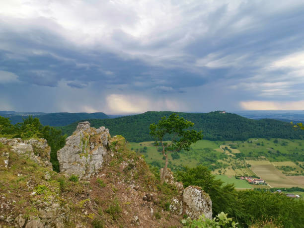 Castle Teck and Breitenstein during a summer thunderstorm with dark clouds and rain veil