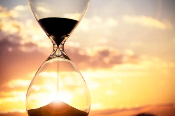 Photo of Hourglass at sunset background with copy space