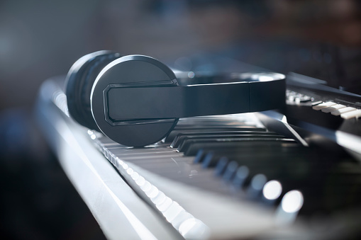 Headphones on piano keyboard concept for live music, tuition, lessons, education or recording