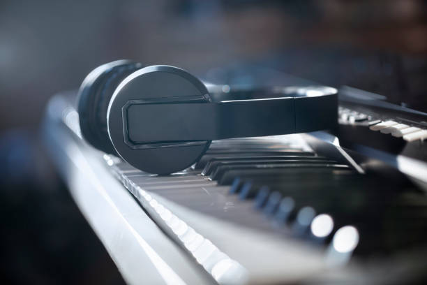 piano keyboard and headphones concept for live music, tuition, lessons and education - piano piano key orchestra close up imagens e fotografias de stock