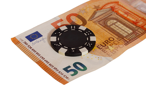 A closeup shot of 50 euro banknote with poker chip isolated on white background