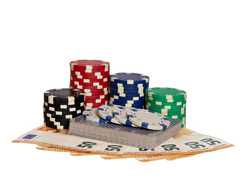 A closeup shot of 50 euro banknotes with playing cards and poker chips isolated on white background