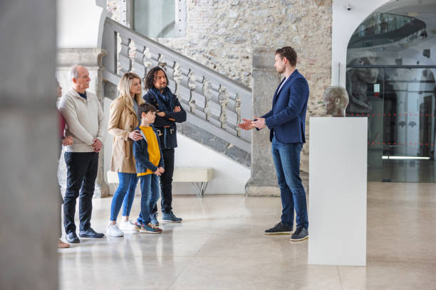 guide touristique du musée pour hommes de race blanche adultes expliquant ce qu’il a prévu pour la visite du musée à ses divers visiteurs - child serious museum indoors photos et images de collection