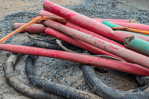 A closeup shot of pipes with red and black colors on the ground