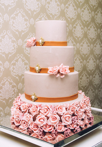 A vertical shot of a wedding cake with flowers on a tray
