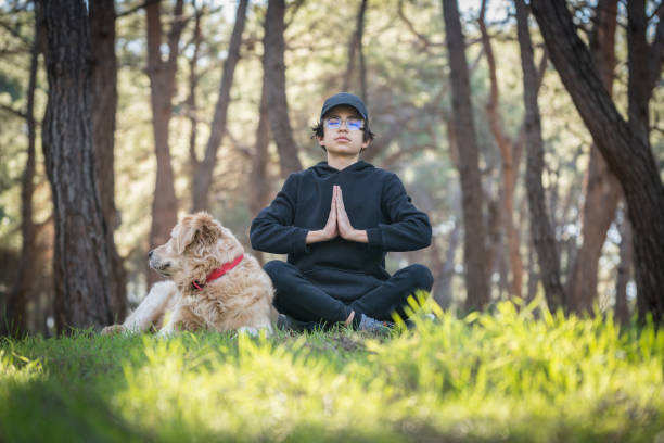 istock Young boy and his dog spending time in forest and meditating 1464715640