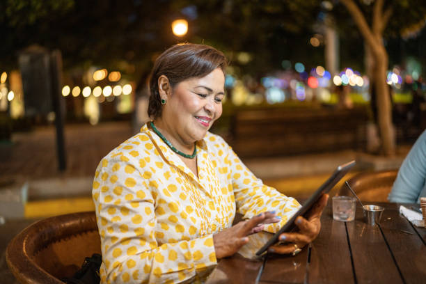 istock Mature woman using digital tablet outdoors 1464716193
