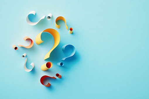 Yellow question mark surrounded by colorful question marks over blue background. Horizontal composition with copy space.