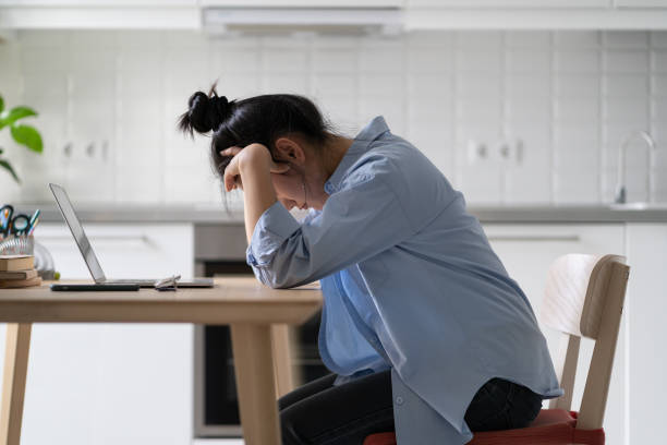 istock Young depressed woman freelancer feeling unmotivated working from home, sitting in front of laptop 1464724575