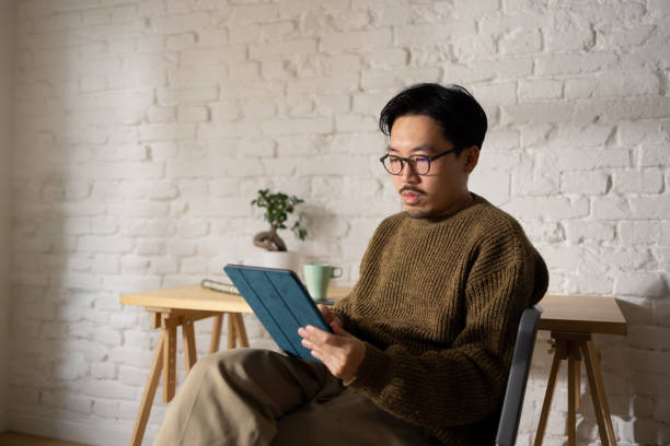 istock A serious-looking Chinese man in his 30s using tablet at home 1464727655