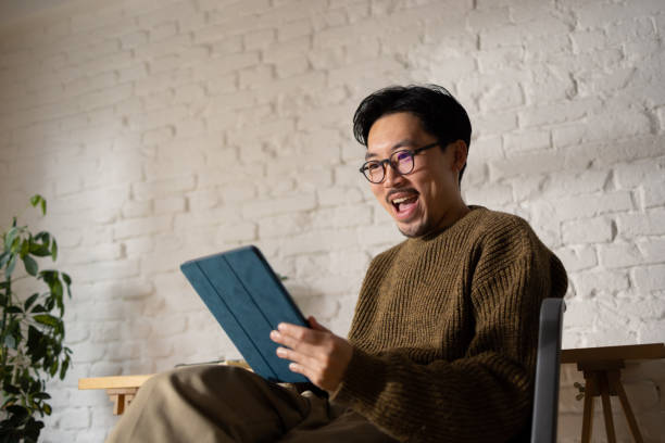 istock Asian male model in his 30s using tablet at his working desk 1464727667