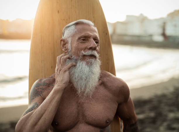 istock Fit senior man having fun practicing surf on tropical beach - Elderly healthy people lifestyle and extreme sport concept 1464727796