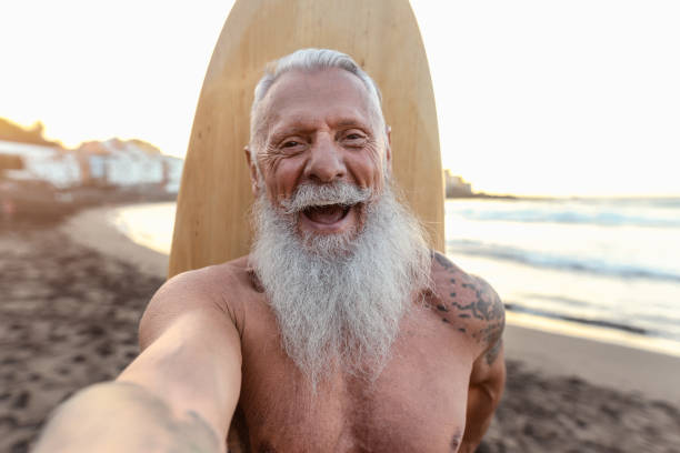 istock Happy senior surfer taking selfie while having fun surfing at sunset time - Elderly health people lifestyle and extreme sport concept 1464728522