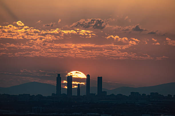 Orange sunset behind the Skyline and towers of the city of Madrid with buildings in silhouette Orange sunset behind the Skyline and towers of the city of Madrid with buildings in silhouette. madrid city view stock pictures, royalty-free photos & images