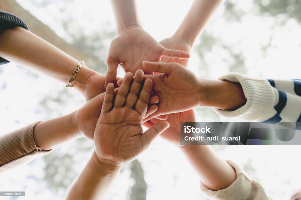 Group of people Shaking hands Low Angle View of young multiracial group of people Shaking hands Circle Stock Photo