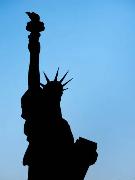 Colmar, France - March 29, 2022: Silhouette of the Statue of Liberty, designed by Frederic Auguste Bartholdi. Statue wrapped with the Ukrainian flag in yellow and blue