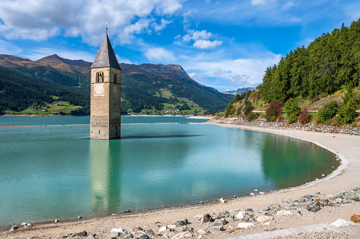 The bell tower of the church remains from the flooded village Graun - Curon in Val Venosta, South Tyrol, Italy