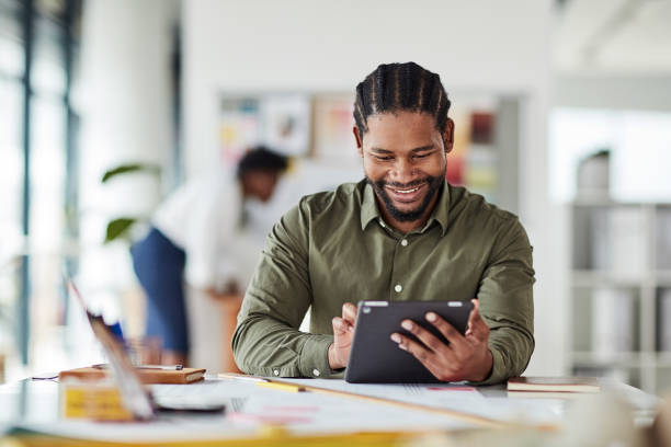 istock Creative workplace, web design and black man with tablet at desk for marketing research, website app and internet. Networking, digital tech and male employee working on strategy, ideas and project 1464735775