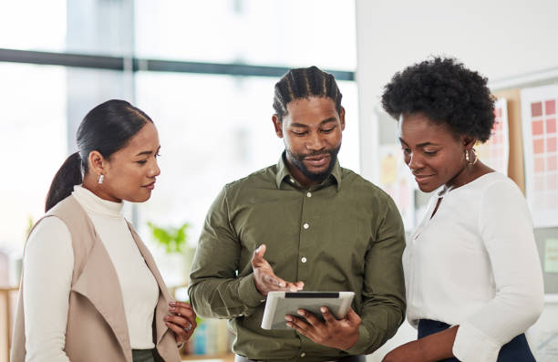 istock Staff, black man and manager with tablet, website launch and brainstorming in workplace or creative. Leadership, African male leader or female employees talking, innovation, office or online schedule 1464735790