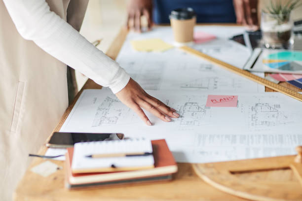 Architecture, blueprint or hands in a meeting planning a creative strategy or building ideas together. People, brainstorming or designers speaking of project job goals with team work or collaboration