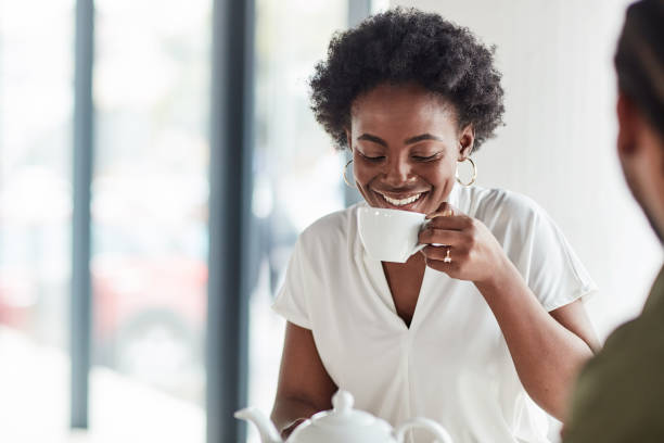 femme noire, thé du matin et café avec bonheur de café boisson prête pour le travail à distance. sourire, pigiste heureux et jeune dans un restaurant se sentir détendu et positif lors d’une pause de travail - coffee shop coffee break coffee cup holding photos et images de collection