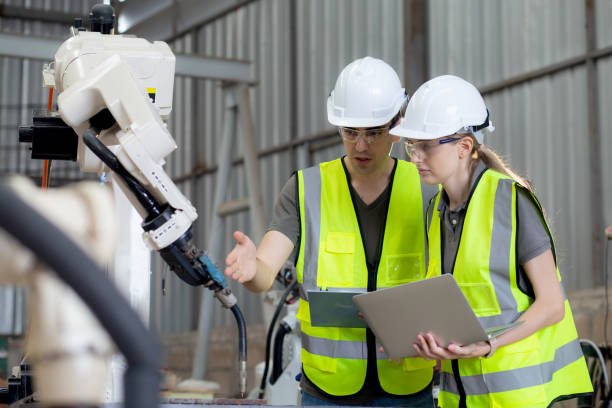 istock Engineer man and woman talking and explaining about robot arms technology intelligence and innovation at factory, development machine robotic, people examining machine electronic, industry concept. 1464737826
