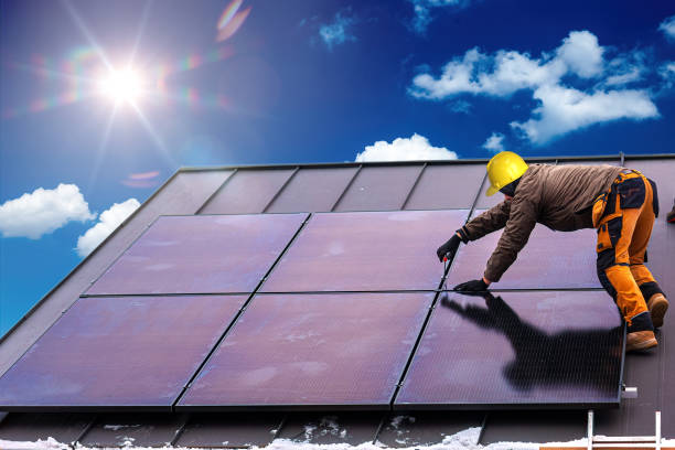istock Solar panel installer installing solar panels on roof of modern house 1464738081