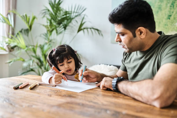 istock Father and daughter sitting at table and drawing on paper 1464739493