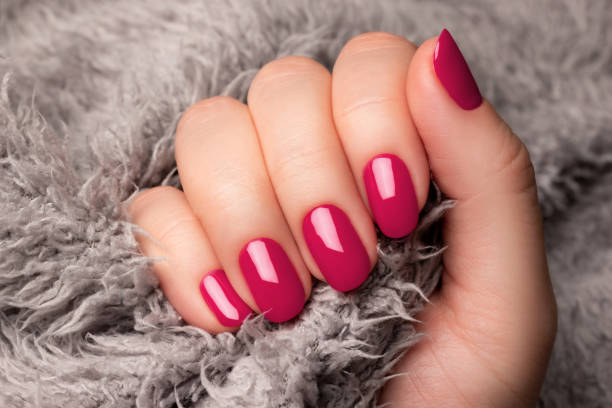 istock Hand with viva magenta nails on gray fluffy fabric 1464739580