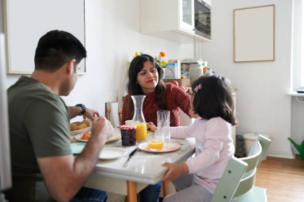 istock Family eating breakfast at dining table in kitchen 1464739745