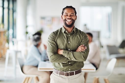 Business, black man and portrait with arms crossed for leadership, management and trust. Smile, happiness and male manager in startup agency with confidence, motivation and professional company goals