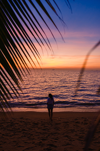 woman watching the sunset on the beach of Pattaya Thailand in the evening