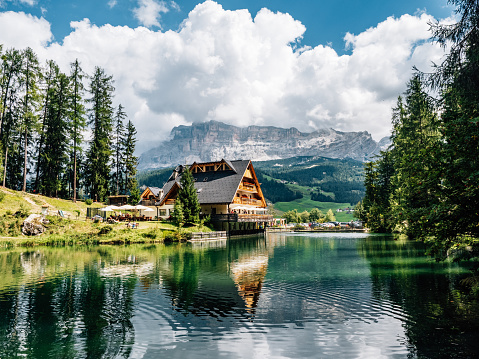 Sompunt lake in Alta Badia, Trentino Alto Adige, Italy. Reflection of a typical house on the lake's water. The building is an hotel/restaurant.