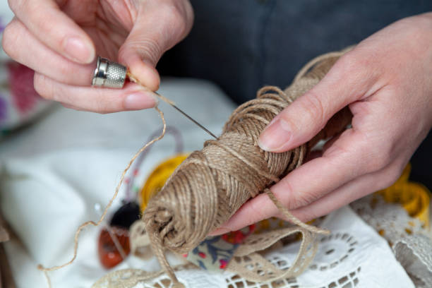 istock Hands of  seamstress working with needle and thimble close-up 1464741648