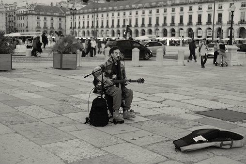 Lisbon, Portugal - November 19, 2022: A street musician perfoms at the Praça do Comércio square in Lisbon downtown.