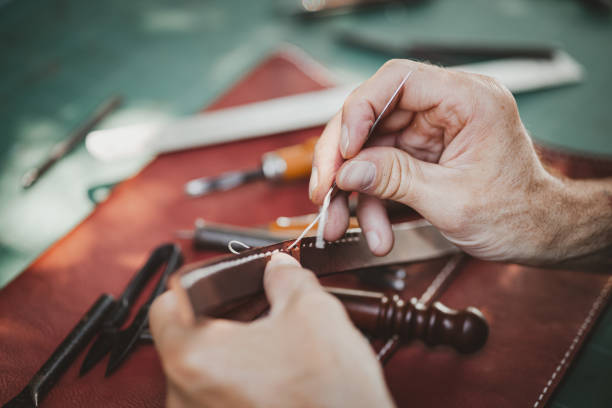 istock closeup hand working process leather handcraft in the leather workshop. Man holding crafting tool and working. He is sewing hammer to make a walet. Tanner in old tannery. 1464742587
