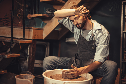 pottery worker male hand crafted made cray pot with tired exhausted from hard work over night try