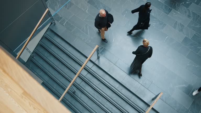 Busy day at the office: View from above of working professionals in motion