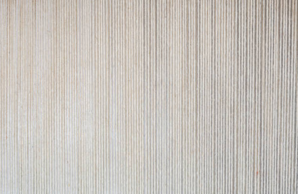 Natural white wool yarn lined up side by side on a carpet loom.
